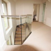 landing with light carpet and glass balustrade