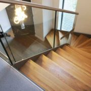 oak steps on a modern glass and steel stair