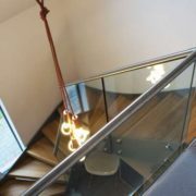 glass landing balustrade at the top of a model steel and wood staircase