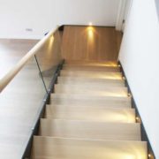 oak steps on a steel and glass stair with platform