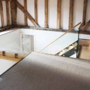 carpeted landing area with frameless glass balustrade