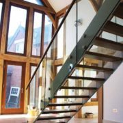 white steel staircase in front of large wood framed window