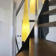 yellow cone light behind a black steel staircase