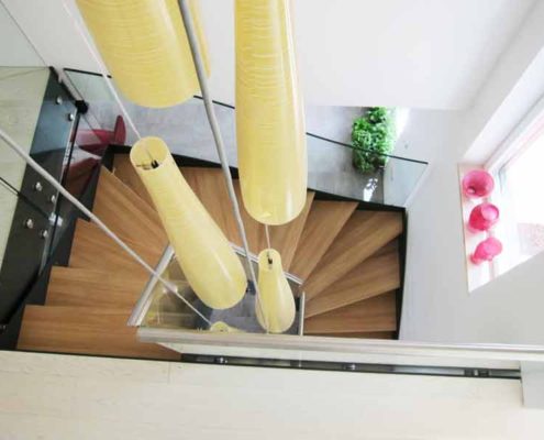 Modern-Stair-Berwick-Upon-Tweed-4 yellow light suspended down a stairwell containing a modern wood and steel staircase