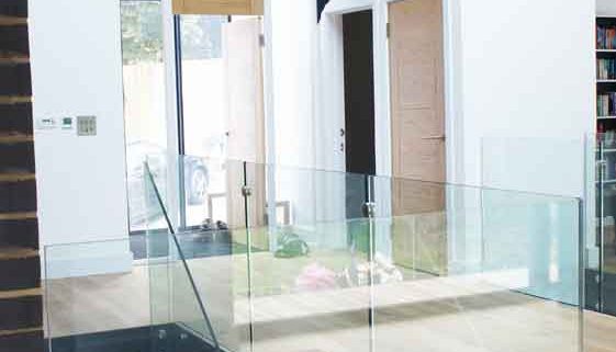 Modern-Staircase-Stamford-5 hallway with front door and timber floor with glass balustrade around stairwell