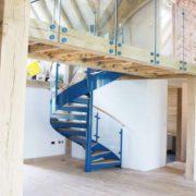 timber walkway with frameless glass panels and blue spiral staircase