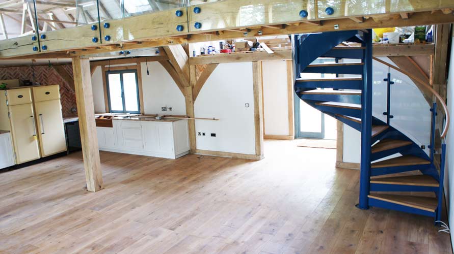 large open floor with timber with blue spiral staircase