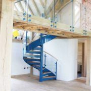 blue steel spiral staircase with curved glass balustrade