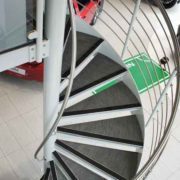 white steel spiral stair with carpeted steps in a car showroom