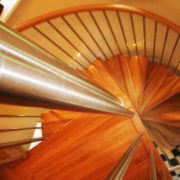 stainless steel newel posts at the top of an oak spiral staircase