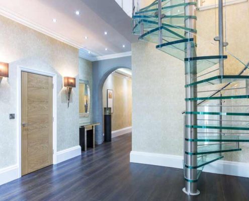 dark wood floored hallway with stainless and glass steps spiral staircase