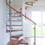 room with wooden floor with window behind and white spiral stair