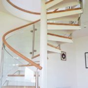 white centre column spiral stair with oak handrail and curved glass balustrade