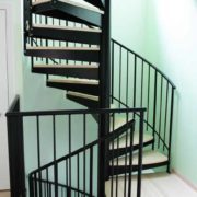 double flight spiral stair in a house with black steelwork and wooden steps