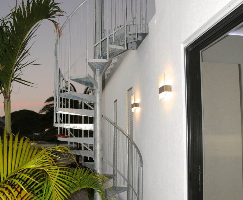 outside spiral stair in galvanised steel with a palm tree