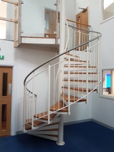 white steel spiral staircase in an officer with stainless handrail