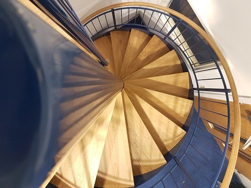 view looking down a blue centre column on a spiral staircase
