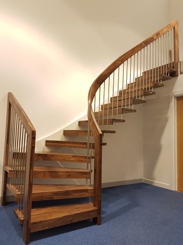 dark wood floating style staircase with a blue carpet