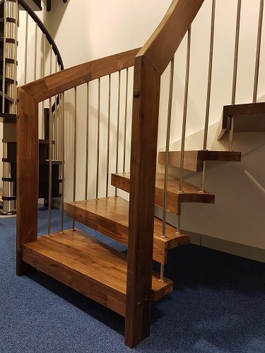 bottom steps of a floating style dark wood staircase