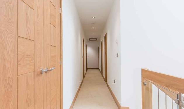 Timber Staircase carpeted hallway above a stairwell