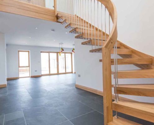 modern open oak floating stair in a hall with dark grey tiles