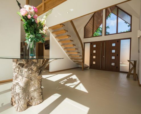 Large hallway with a glass table and a floating timber staircase
