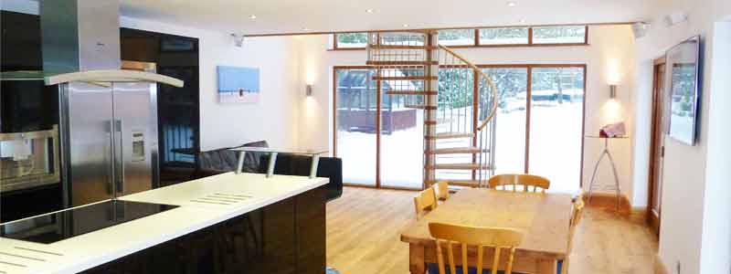 kitchen dining area with large spiral stair and large window to rear