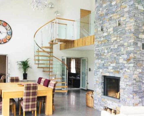 large dining and living space with dining table and glass and oak spiral staircase