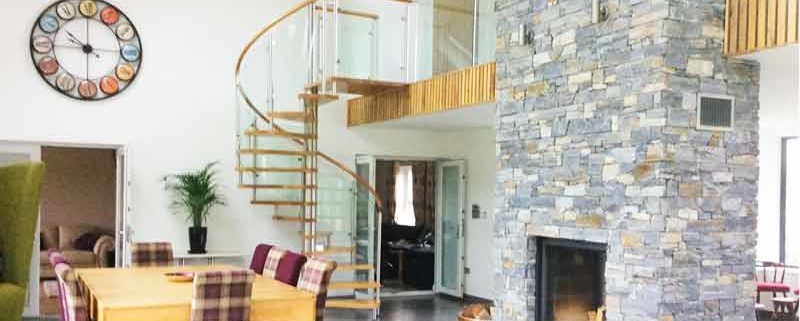 large dining and living space with dining table and glass and oak spiral staircase