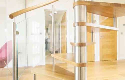 bottom section of an open riser oak spiral stair with stainless column