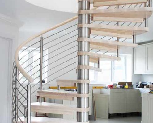 light wood spiral staircase with stainless steel balustrade