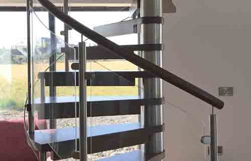 dark wood spiral stair Infront of window showing countryside