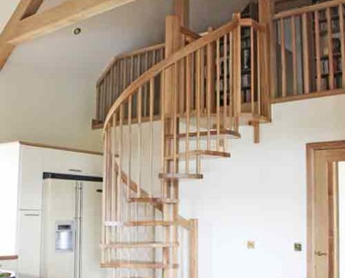 solid oak spiral stair leading upto a mezzanine level within a kitchen