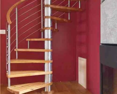modern spiral staircase in front of dark red wall in a house