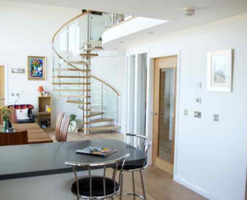 kitchen diner with breakfast bar and glass and oak spiral staircase