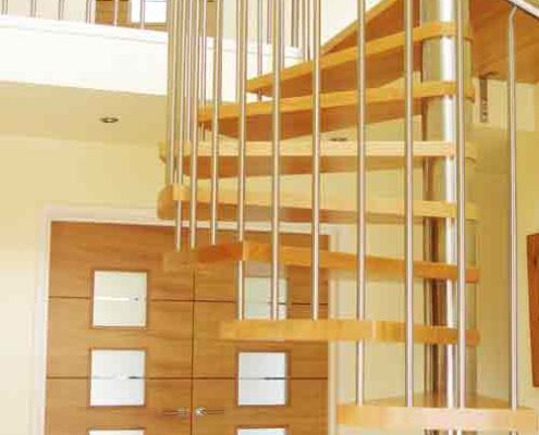 spiral stair with stainless handrail and wooden steps with doorway above and below