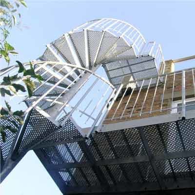 Balcony-3 underside of a perforated steel spiral staircase with blue sky above
