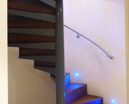 spiral stair enclosed by a curved wall with timber and steel