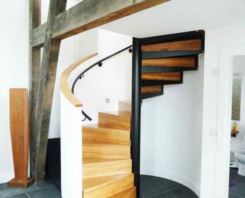 enclosed spiral stair in a house with oak steps and risers
