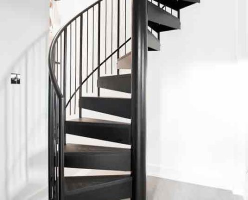 small black spiral staircase with light grey floor below