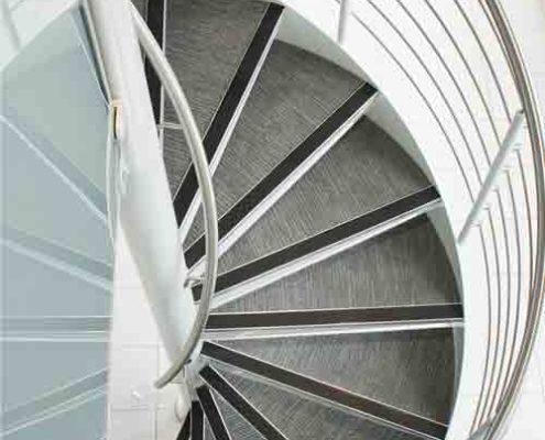 spiral stair with carpeted steps and steel column