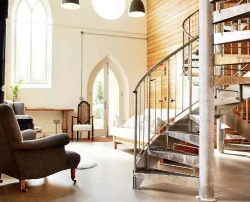 internal galvanised steel spiral stair with chair and sofa on view