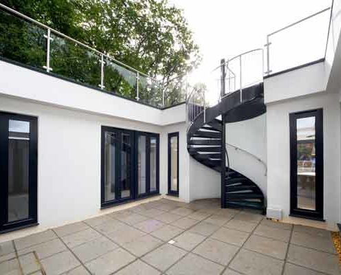 dark grey spiral stair in a courtyard