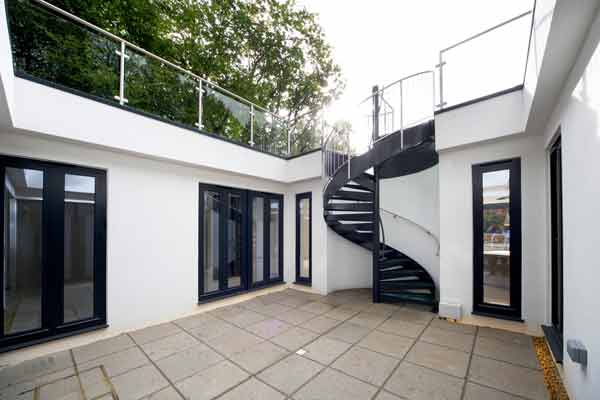 dark grey spiral stair in a courtyard