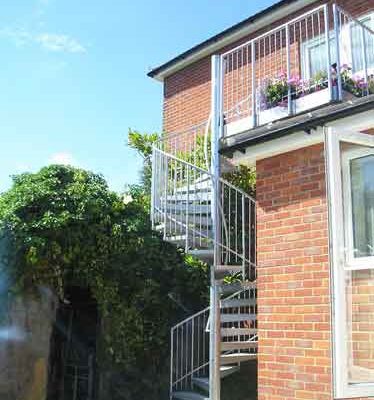 external spiral stair leading upto a balcony to the rear of a house
