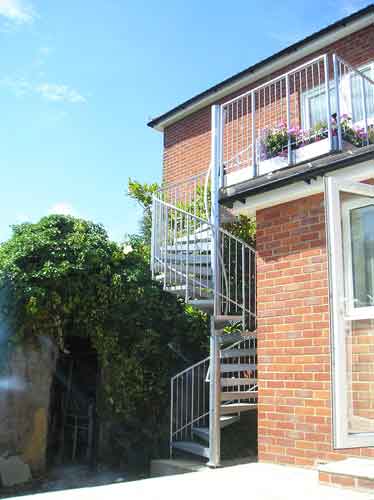 external spiral stair leading upto a balcony to the rear of a house
