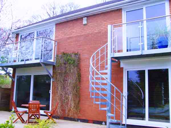 back of house with two balconies , one with a spiral staircase