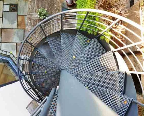 perforated grey steel steps on a spiral stair outside