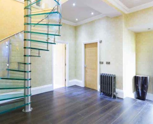 dark floor hallway with a glass step spiral stair rising above