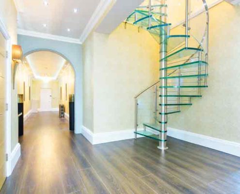 glass spiral staircase in a large hallway